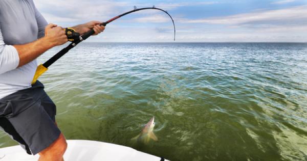 A man fishing for a shark with a custom fishing rod