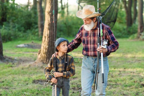 A young kid is heading out to fish with an older man