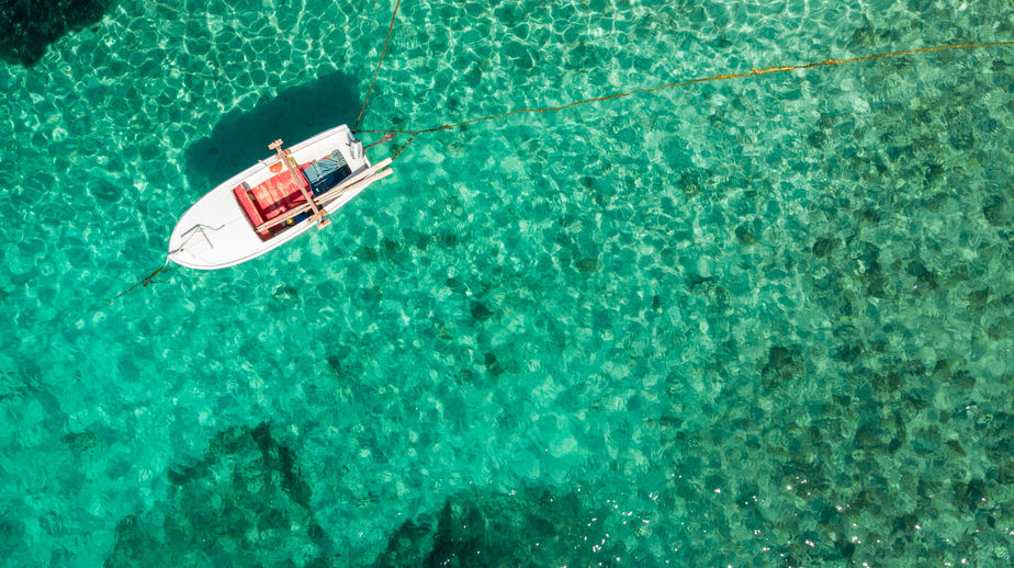 A boat sitting in the middle of a salt water body